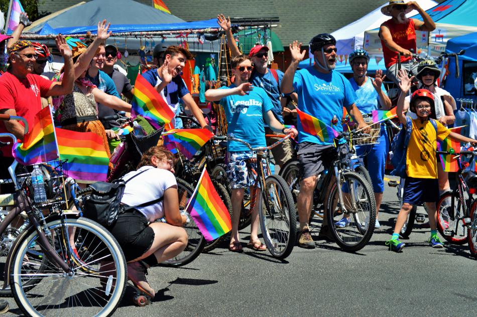 Photo by Brett Fisher. Parade bicyclists wave to supporters in the parking lot of Carson Hot Springs Resort Saturday.