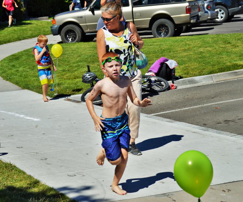 Photo by Brett Fisher. A boy hurries to his bicycle after completing his pool lap.