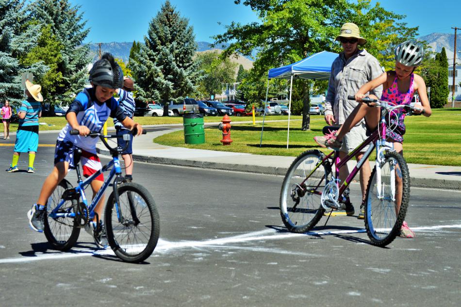 Photo by Brett Fisher. Children transition onto their bicycles on the second leg of the triathlon.