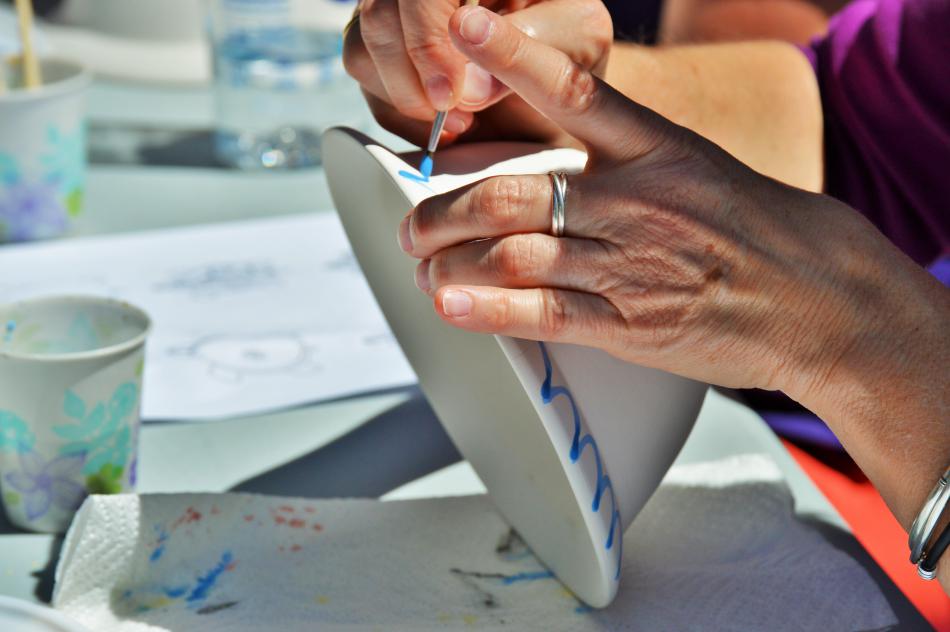 Photo by Brett Fisher. One hand steadies and the other works the brush Saturday.