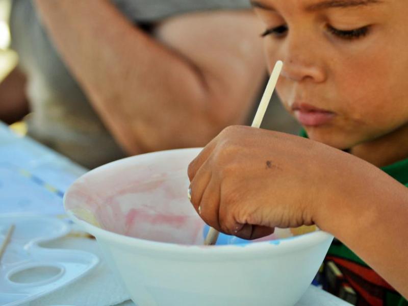 Photo by Brett Fisher. A young artist paints a bowl Saturday for Empty Bowls.