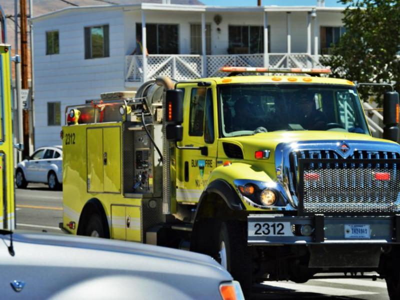 Photo by Brett Fisher. A procession of wildland fire engines leaving Walton's Funeral Home at Roop and William streets.