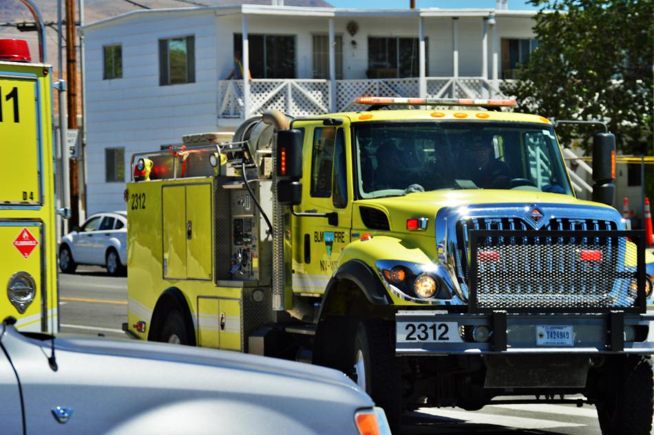 Photo by Brett Fisher. A procession of wildland fire engines leaving Walton's Funeral Home at Roop and William streets.