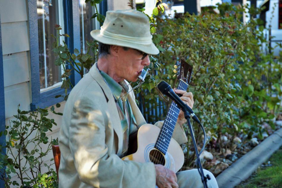 Photo by Brett Fisher. Chris Bayer playing guitar and harmonica.