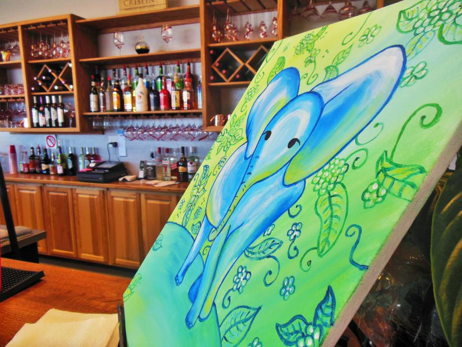 Full bar behind a painting at Mona Lisa and Wine.