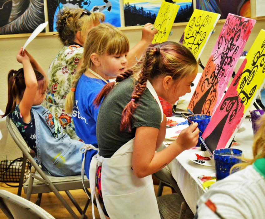 A girl laughs during a painting session at Van Gogh and Vino.