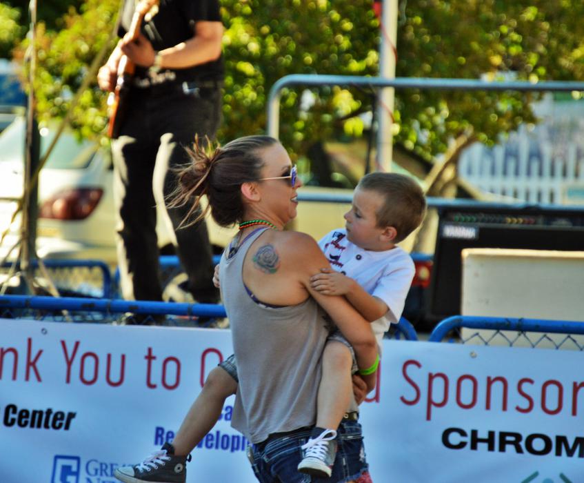 A mother dances with her young son in front of the stage at Telegraph Square.