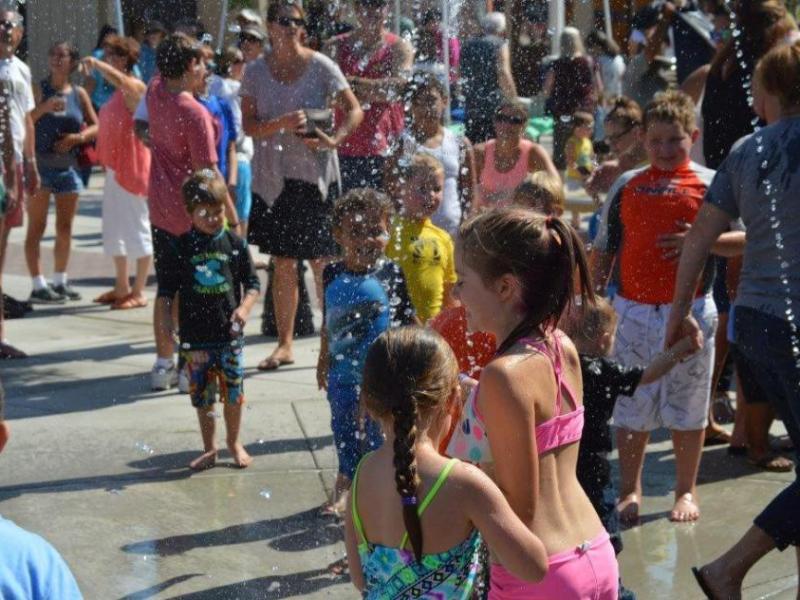 Photo by Lisa Fisher. Children enjoy the new splash pad at Bob McFadden Plaza.