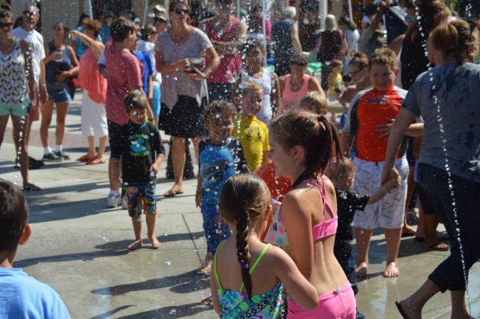 Photo by Lisa Fisher. Children enjoy the new splash pad at Bob McFadden Plaza.