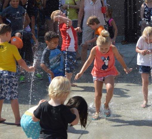 Photo by Lisa Fisher. The splash pad at Bob McFadden Plaza was a popular place for children Saturday morning.