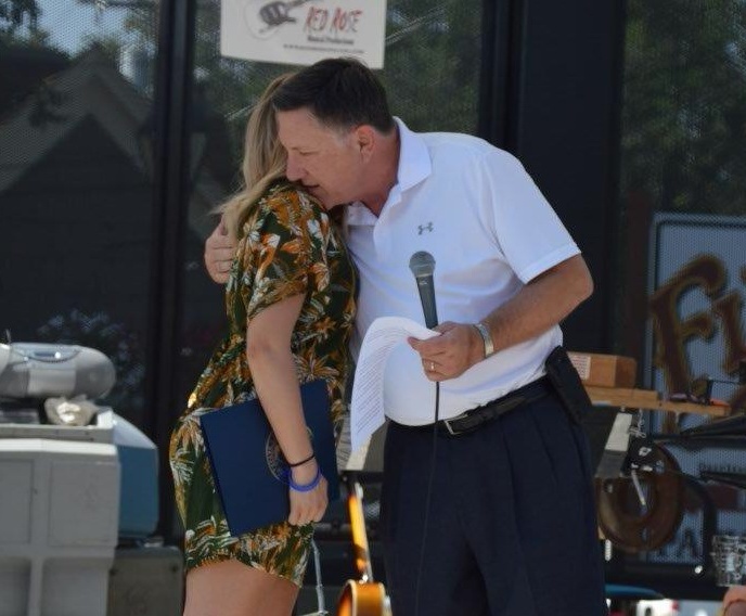 Photo by Lisa Fisher. Assemblyman P.K. O'Neill hugs Carson McFadden after presenting her with a proclamation.