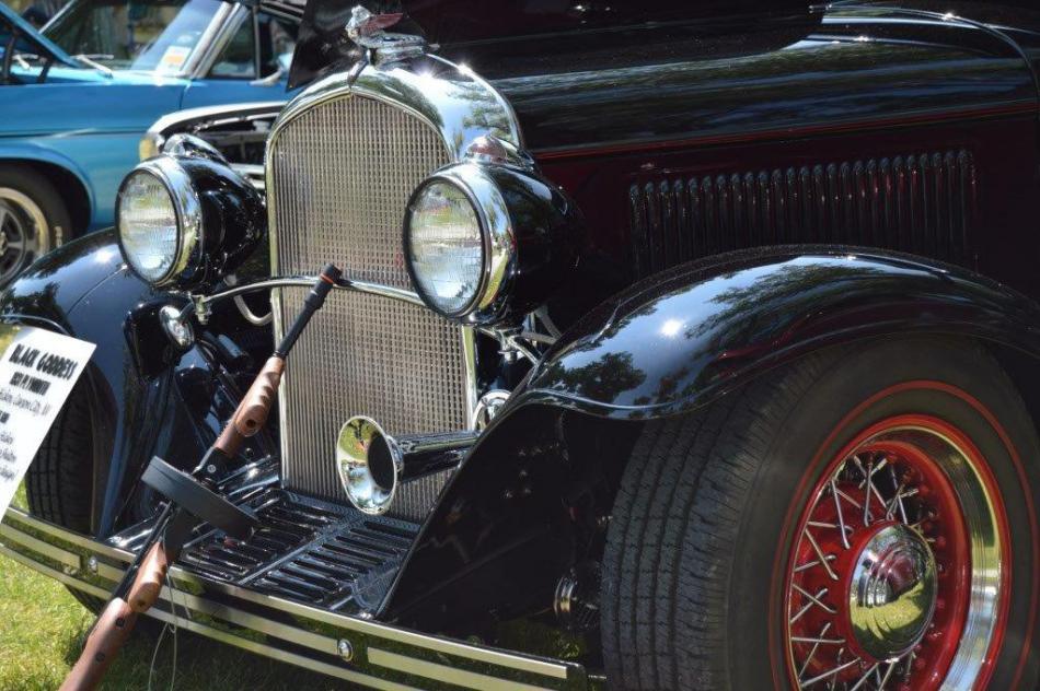 Thompson sub-machine gun prop leans against the grill of this 1930s model classic car.