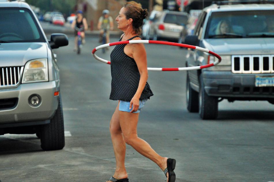A woman dances with a hula hoop on Curry Street at Bob McFadden Plaza.