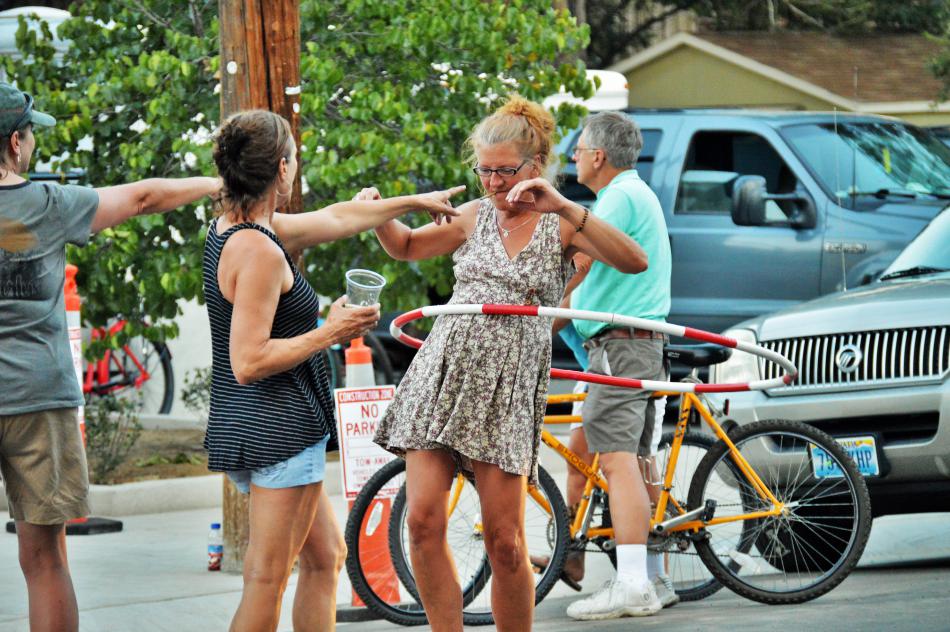 A woman entertains others with a hula hoop along Curry Street next to Bob McFadden Plaza.