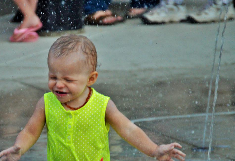 A toddler experiences the splash pad Saturday night on the plaza.