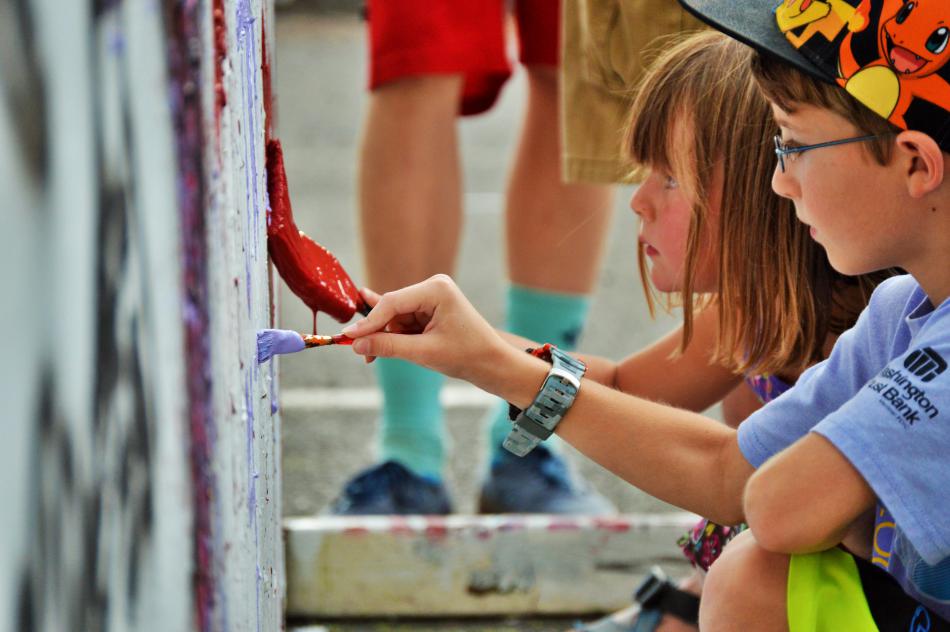 Children paint on the BAC's art wall during a Levitt-AMP concert.