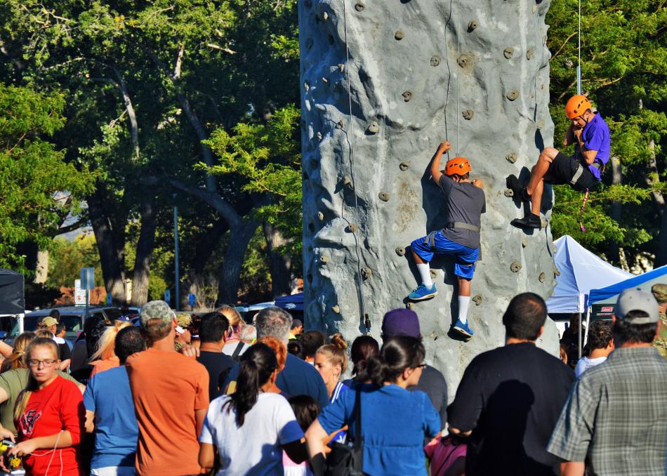 A crowds watches youths on the descend the rock climbing wall.