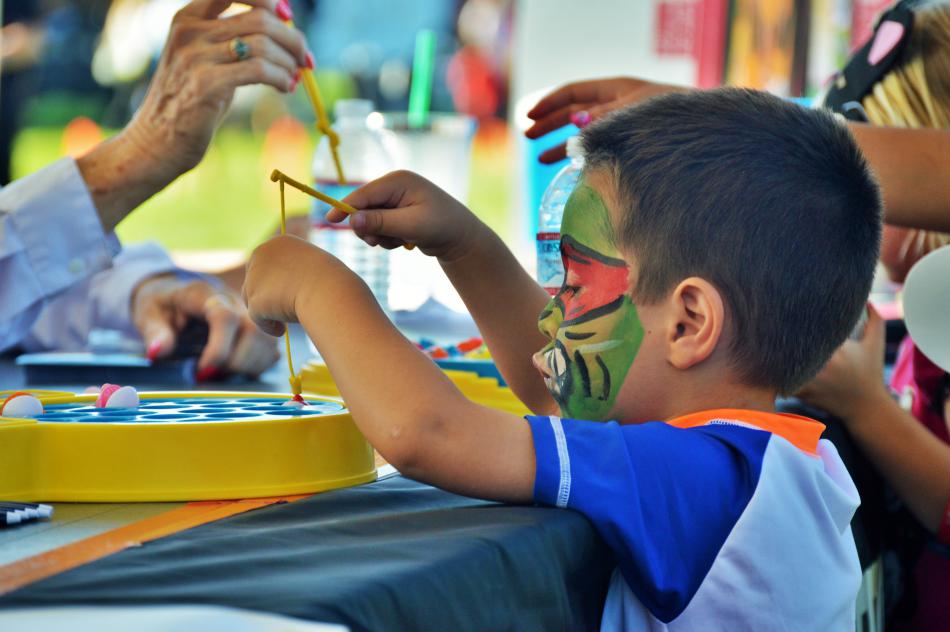 A boy with face paint plays a fishing game Tuesday night.