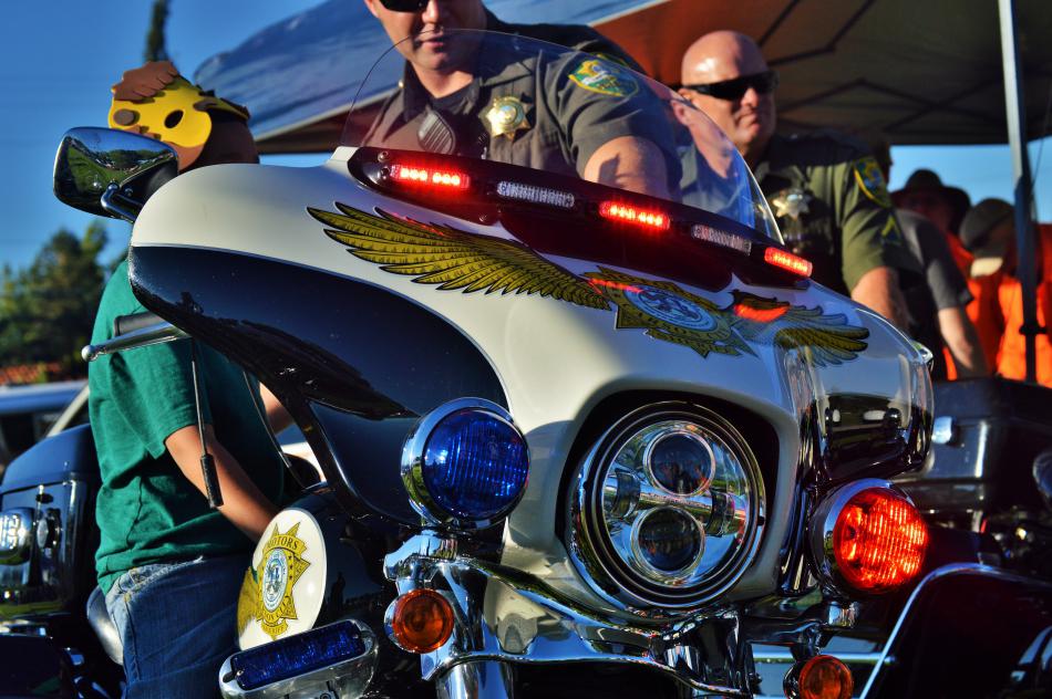 A CCSO motor officer teaches a child about patrol bikes.