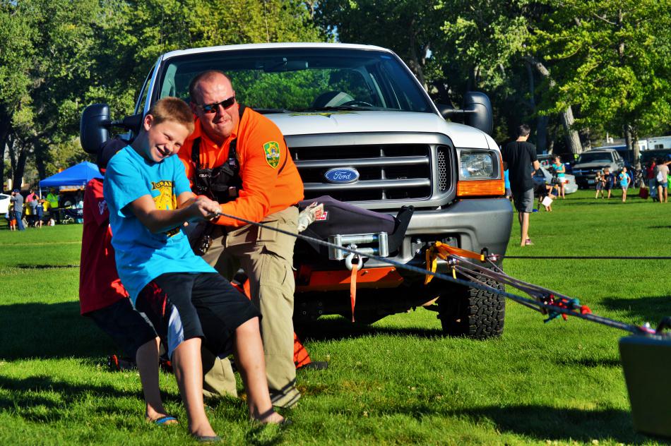 A youth and a CCSO SAR officer work together to pull the SAR Jeep.