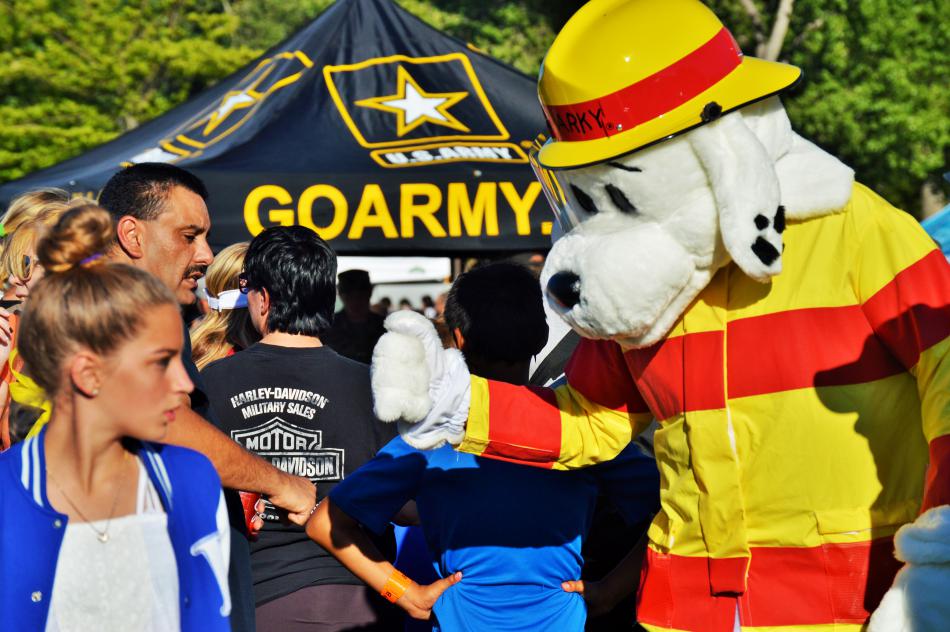 Sparky the Fire Dog fist-bumps a visitor.