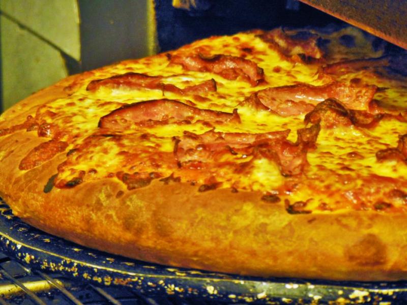 Photos by Brett Fisher. A thick crust pizza fresh out of the oven at Thick Slice Pizza.