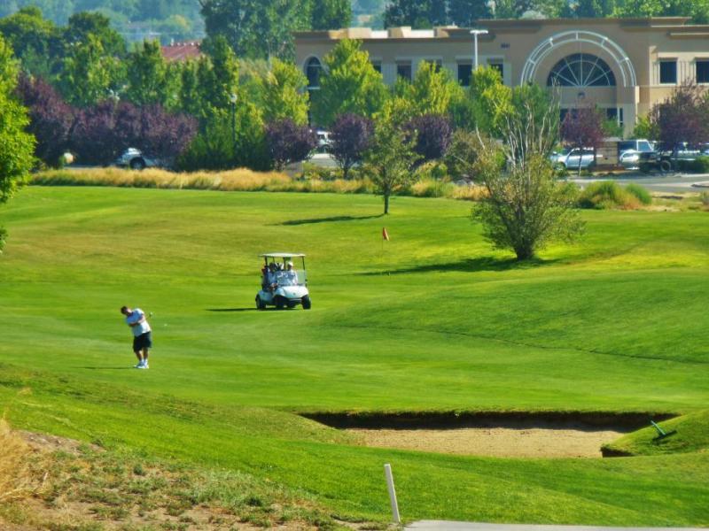 Photos by Brett Fisher. A golfer hits from the fairway toward the green at Silver Oak.