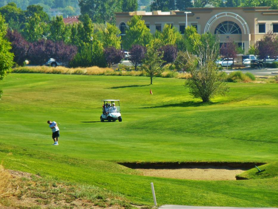 Photos by Brett Fisher. A golfer hits from the fairway toward the green at Silver Oak.