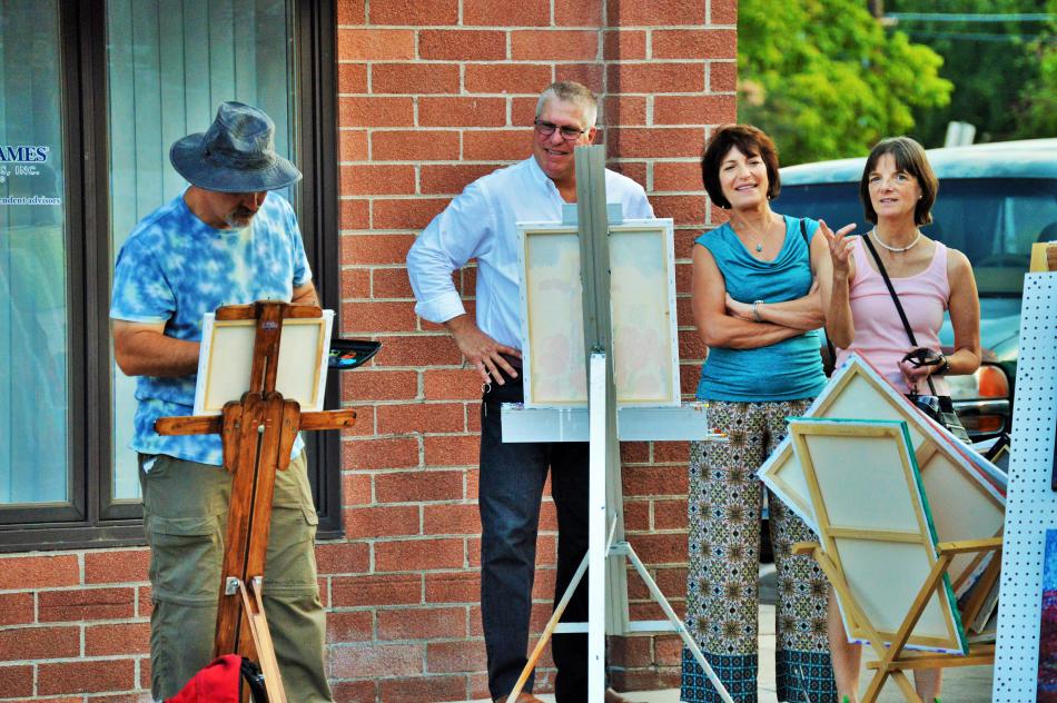 Painter visits with admirers of his work Thursday evening on Telegraph Street.