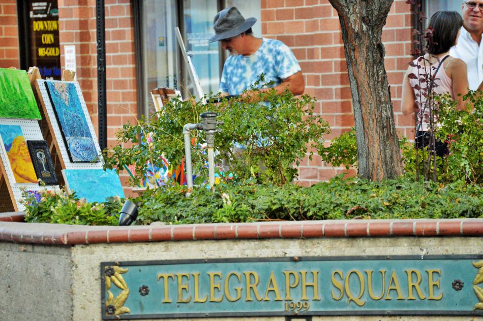 Photos by Brett Fisher. A painter displays his works and provides an art demo at Telegraph Square.
