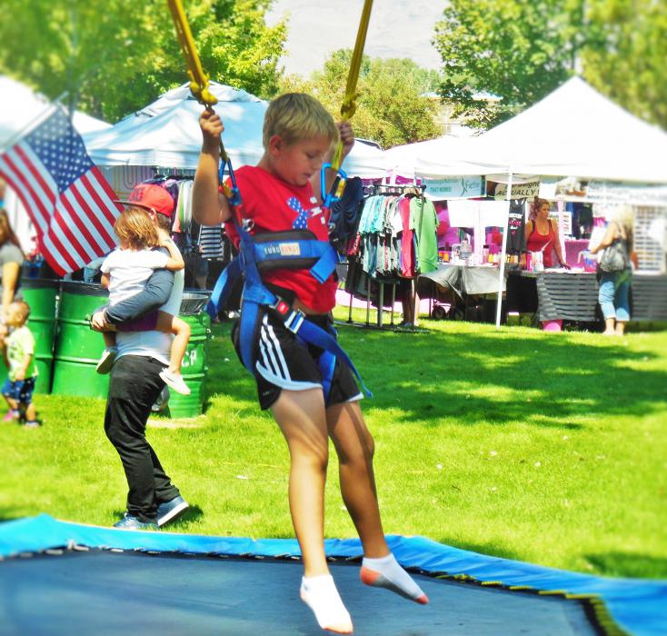 A boy on the bungee lines in the Kids Zone at Mills Park.