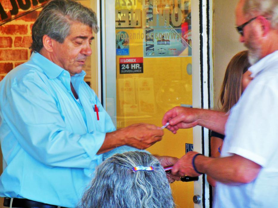 Franchise owner Michael Kubrich hands a prize to a customer after drawing a raffle ticket.