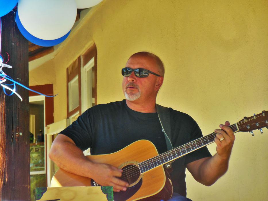 Everett Musselman providing guitar and vocals during Saturday's grand opening celebration.