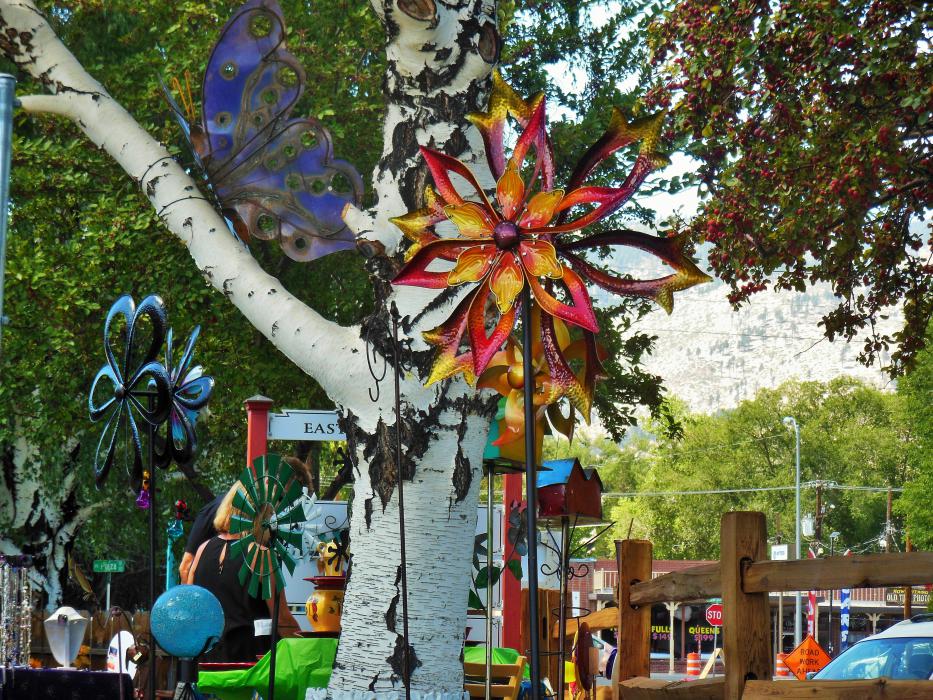 Metal lawn art framed by a large birch tree.