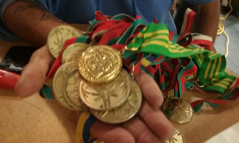 Tyrone Schultz displays his gold medals that outdo Michael Phelps.