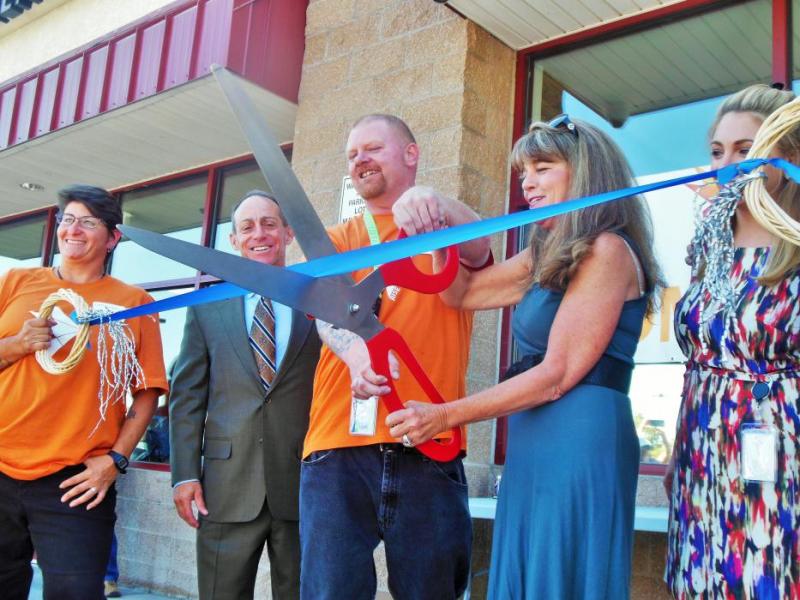 Photos by Brett Fisher. Tyler Brennan (left) and Karen Abowd cut the ribbon Thursday at the new Rise Dispensary.