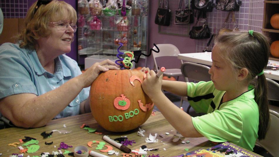 Pat Hughey, left, with her granddaughter Alison, 7, at a pumpkin making table Saturday at Carson Mall.