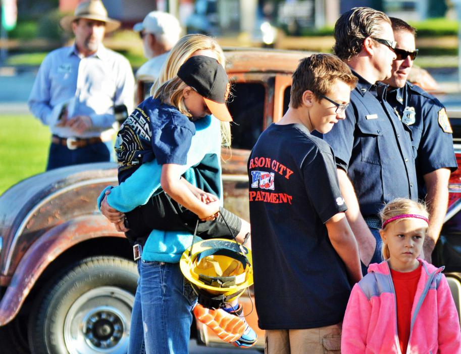 A mother (left) holds her child prior to the 9/11 ceremony at Mills Park.