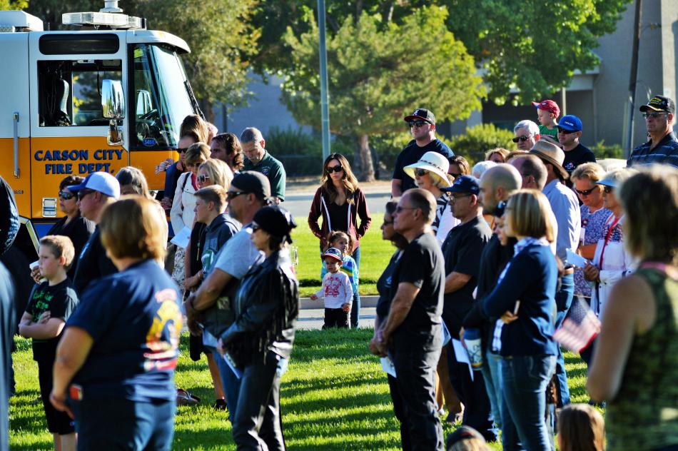 The crowd at Mills Park observes a moment of silence after the flag was lowered to half mast.