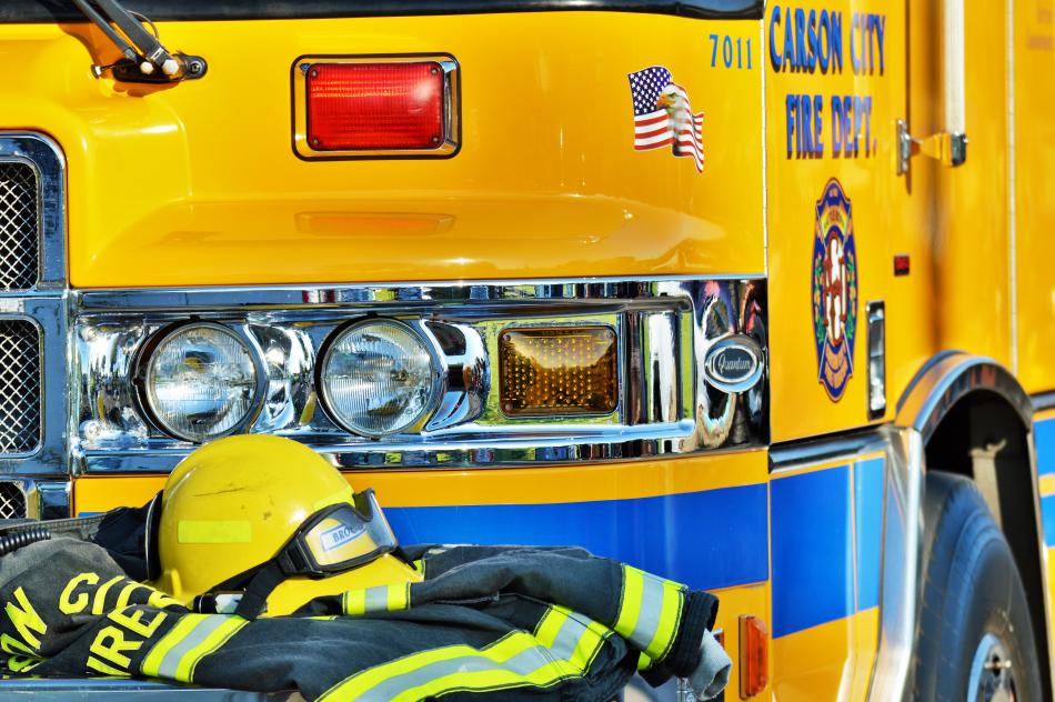An engine with firefighter gear parked along the curb near the 9/11 memorial at Mills Park.