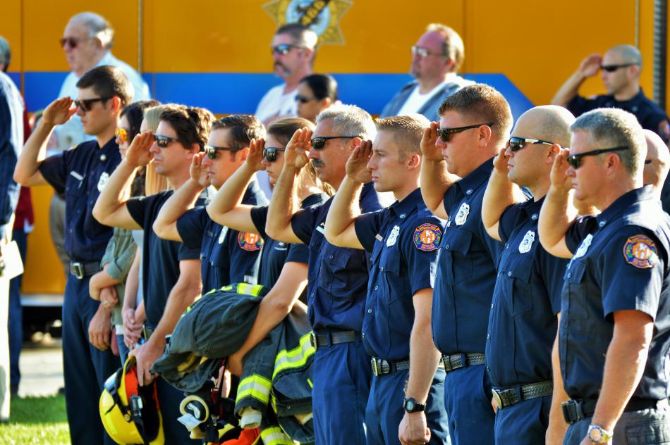 Members of the Carson City Fire Department stand in a line and salute during the National Anthem.