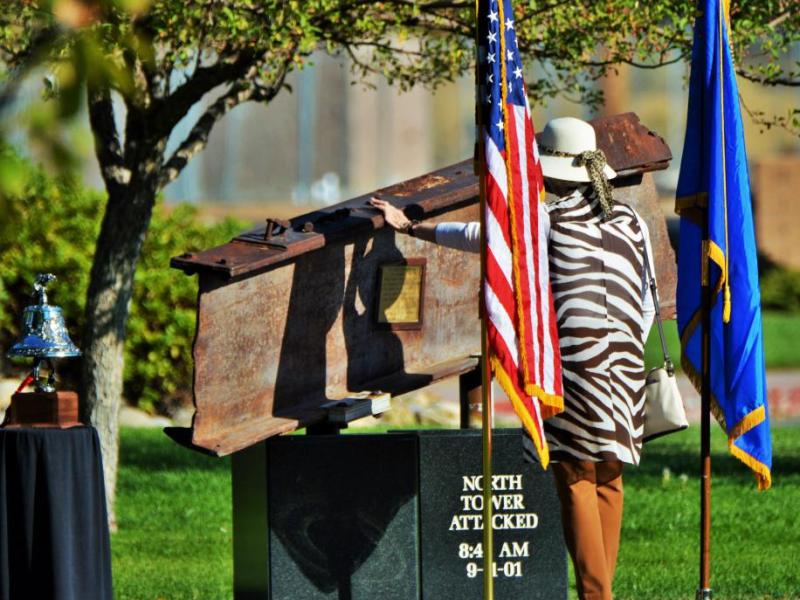 Photos by Brett Fisher. A woman touches the I-beam of the 9/11 Memorial at Mills Park Sunday morning.