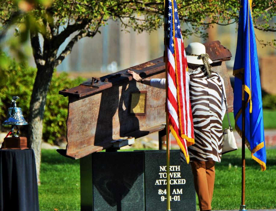 Photos by Brett Fisher. A woman touches the I-beam of the 9/11 Memorial at Mills Park Sunday morning.
