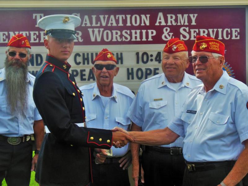 Photos by Brett Fisher. U.S. Marine Josiah Cyr (left) is congratulated by local Marine Corps League members.