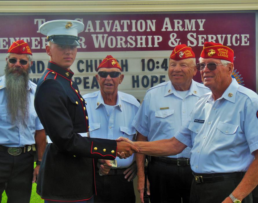 Photos by Brett Fisher. U.S. Marine Josiah Cyr (left) is congratulated by local Marine Corps League members.