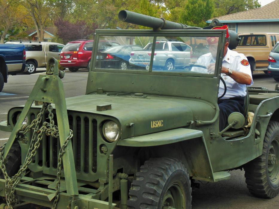 Marine Corps League Commandant Gary Armstrong behind the wheel of a vintage USMC Jeep.