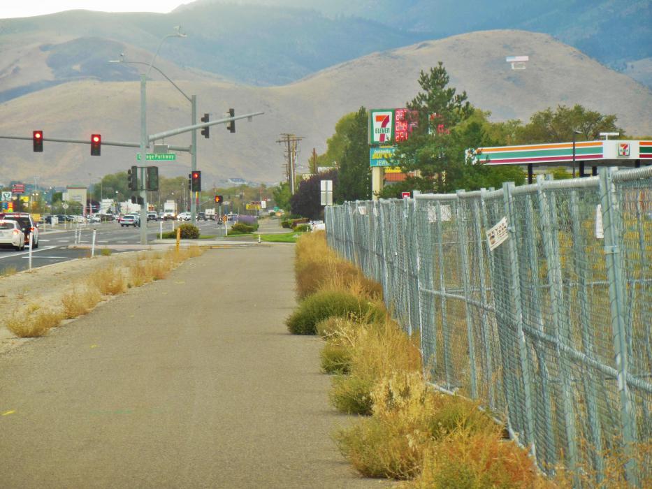 Chain link fencing stretches to the corner of Hwy 50 East and College Pkwy.