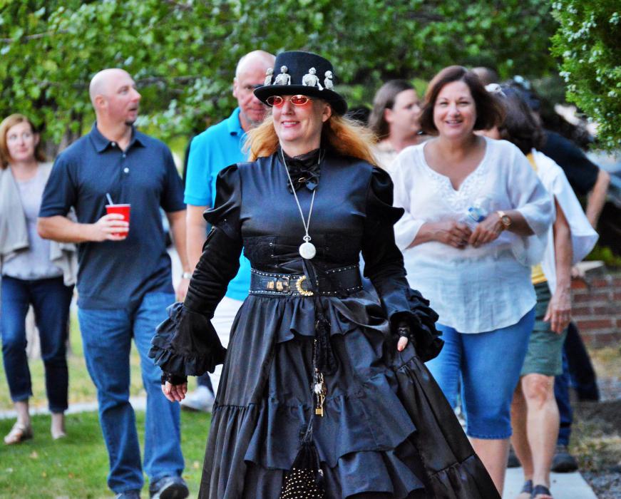 Madame Curry (Mary Bennett) leads her tour group Saturday evening along Third Street toward Minnesota.