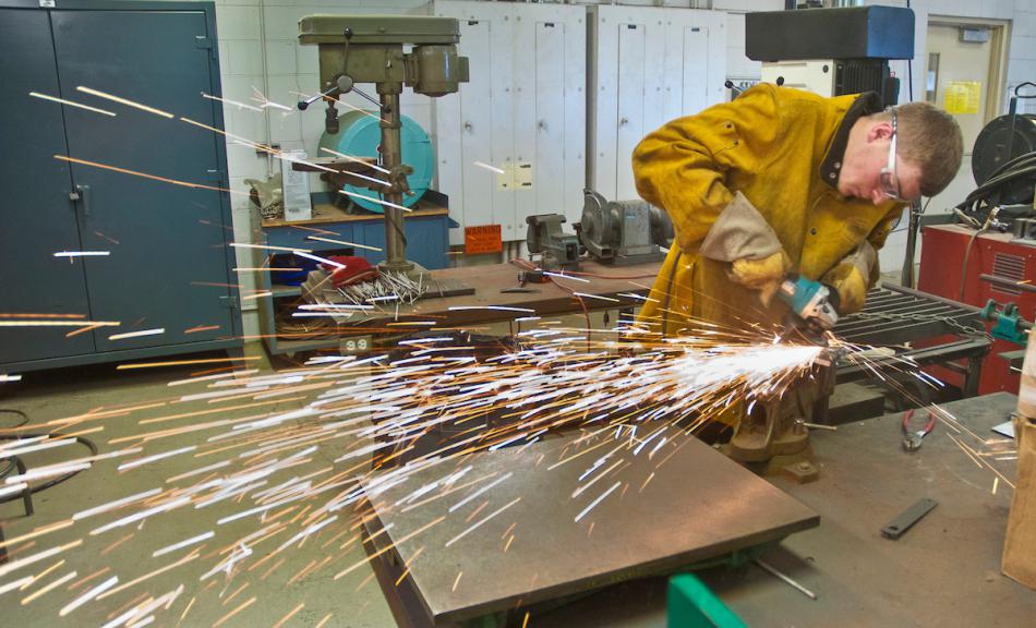 Western Nevada College student Kovey Huckaby grinds a backing plate as part of his certification test in a welding class.