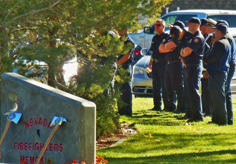 Carson City firefighters and paramedics listen to the memorial dedication Saturday.